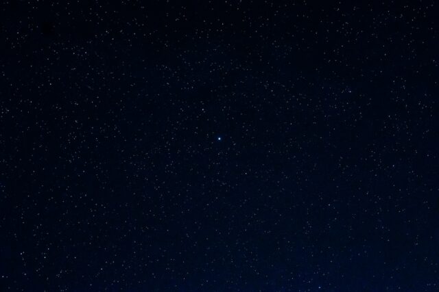 a night sky with a few stars and the moon