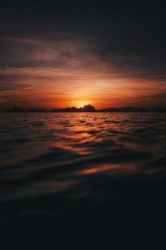 the sun is setting over a body of water