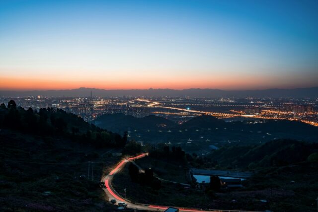 a view of a city at night from a hill