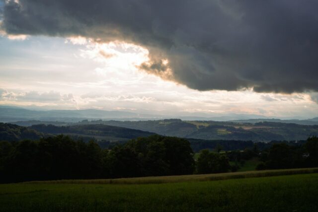 green grass field under white clouds during daytime